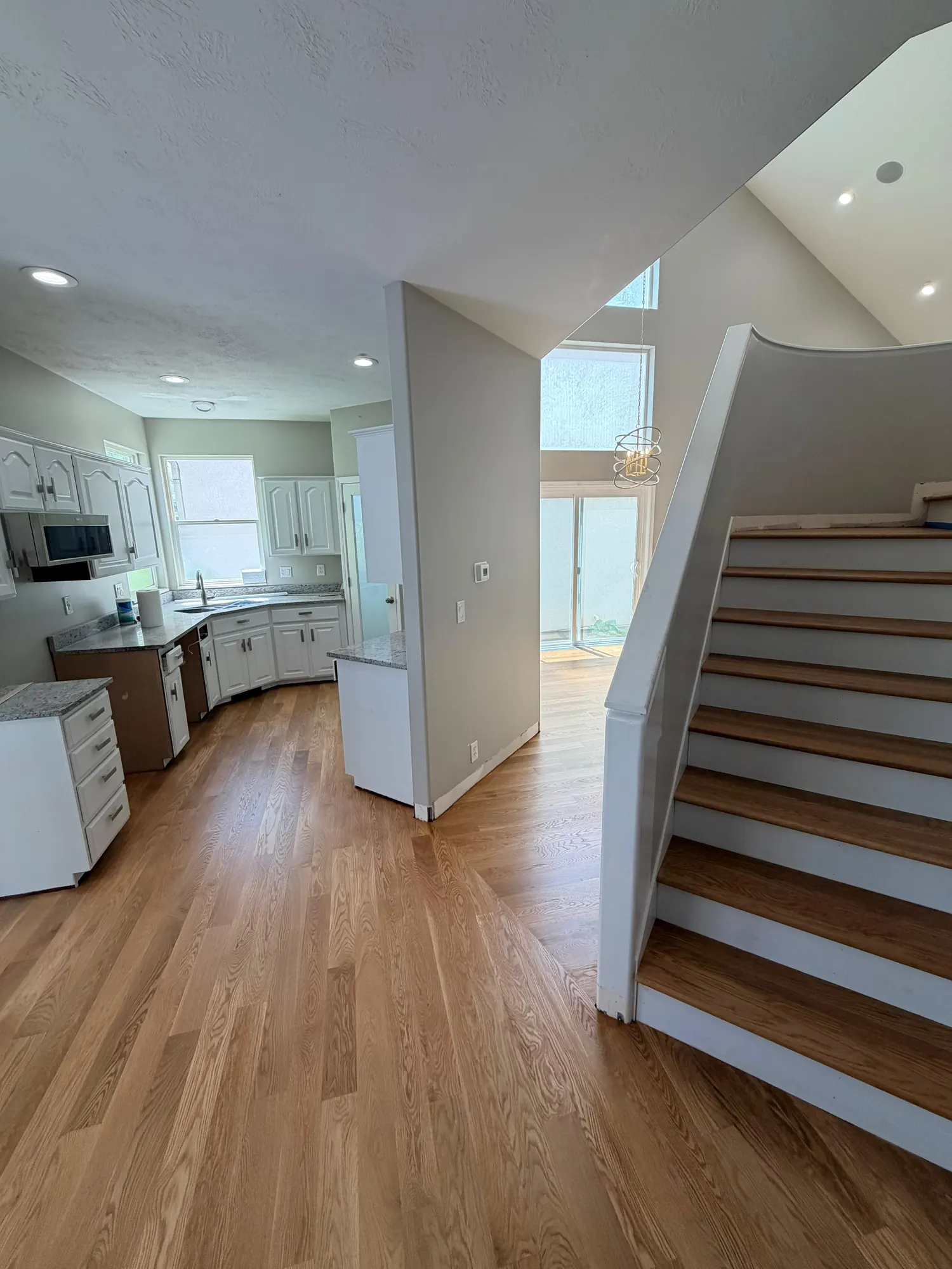 Real Plank & Go hardwood kitchen flowing into a curved stair stringer in a Utah home